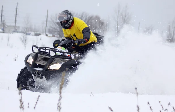 Fyrhjuling föraren Rider över snö spår — Stockfoto
