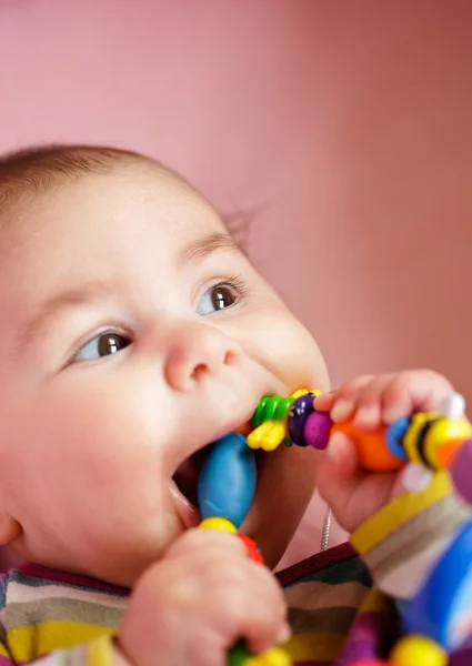 O bebê está roendo um brinquedo — Fotografia de Stock