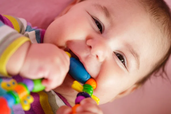 O bebê está roendo um brinquedo — Fotografia de Stock