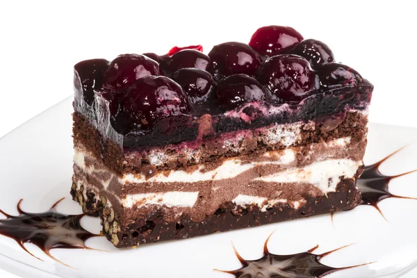 Pastel de chocolate con cereza encima sobre un fondo blanco — Foto de Stock