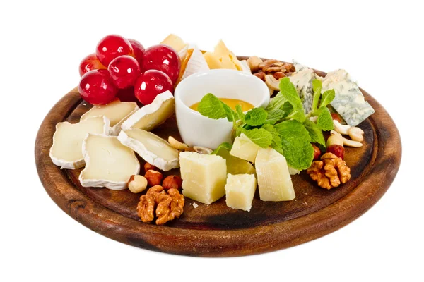 Diferite tipuri de brânză cu miere, nuci și struguri pe farfurie, este — Fotografie, imagine de stoc