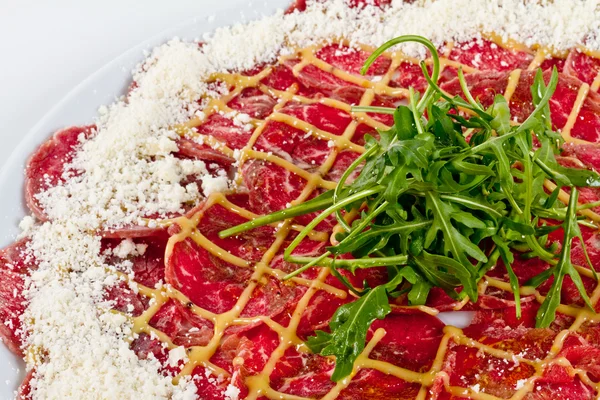 stock image Meat (beef) Carpaccio with Parmesan Cheese and ruccola