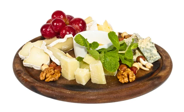 Различные виды сыра с медом, орехами и виноградом на тарелке, является — стоковое фото