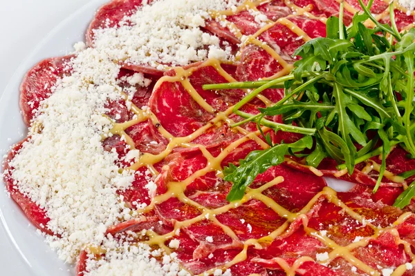 stock image Meat (beef) Carpaccio with Parmesan Cheese and ruccola