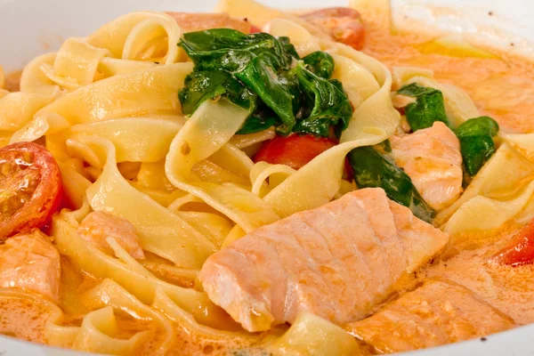 Smakelijke pasta met zalm, kaas, room en peterselie close-up — Stockfoto