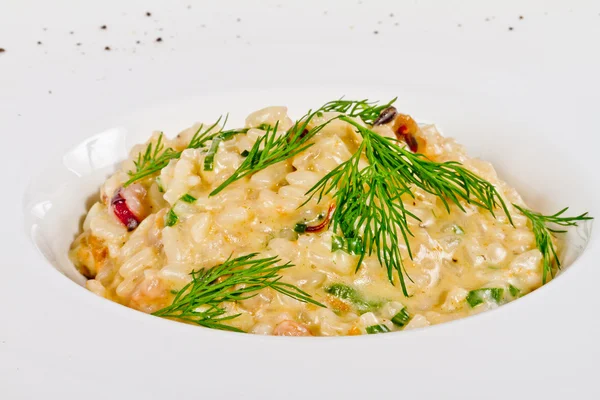 Foto de delicioso risotto con mariscos y eneldo en ella —  Fotos de Stock