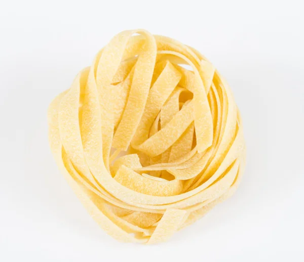 Nido di fettuccine di pasta isolata su fondo bianco — Foto Stock