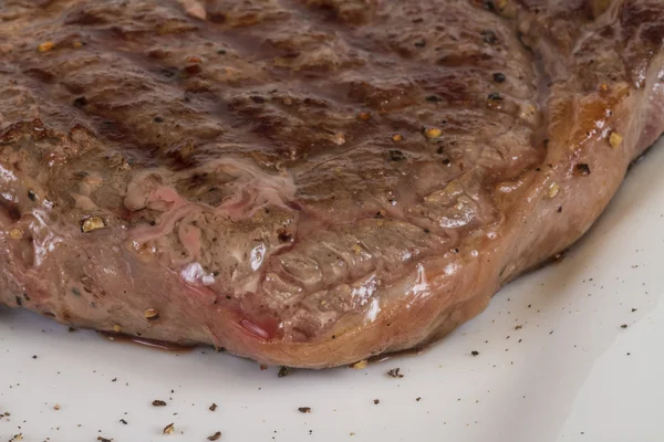 Bife de carne grelhada isolado em um fundo branco — Fotografia de Stock