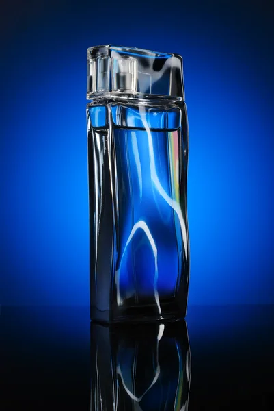 Дизайнери пляшка чоловіка парфуми з відображенням на синьому спині — стокове фото