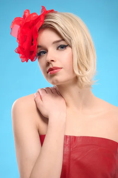 Blond kvinna med en röd blomma i håret — Stockfoto