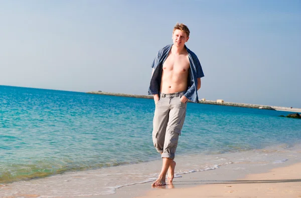 Mocny młody człowiek na plaży — Zdjęcie stockowe