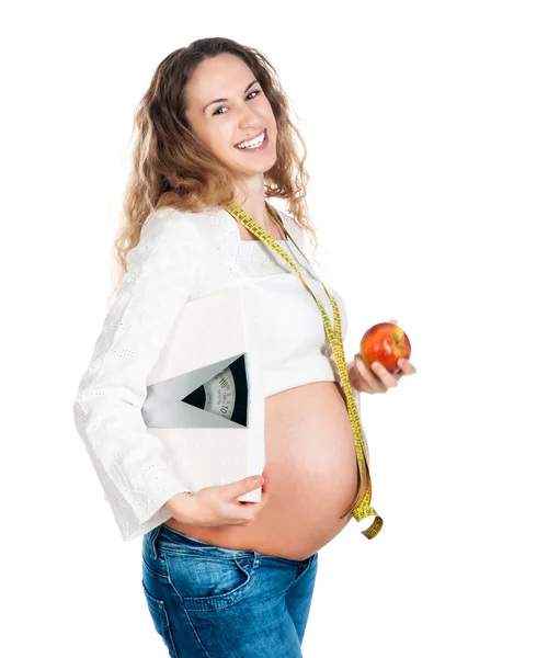 Mujer embarazada con escamas de manzana y peso —  Fotos de Stock