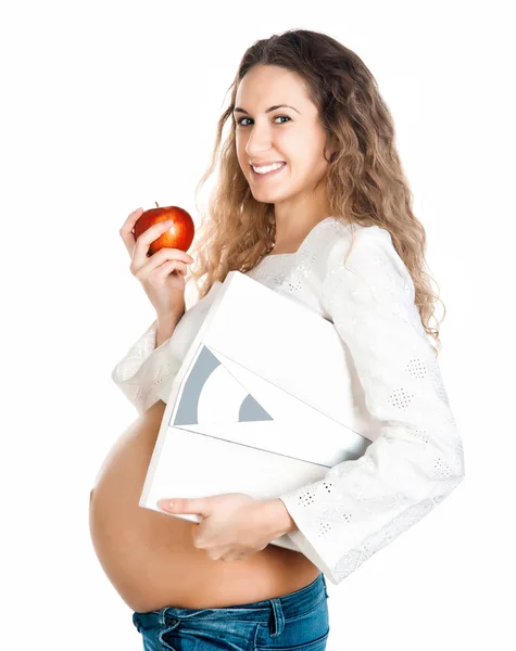 Gravid kvinna med äpple och vikt skalor — Stockfoto