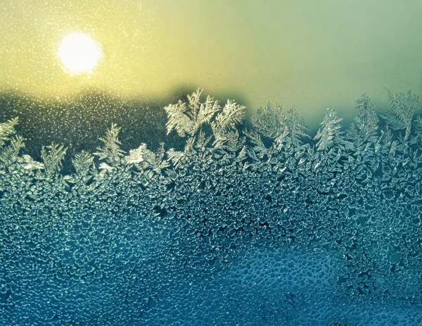 Padrões de gelo e sol no vidro de inverno — Fotografia de Stock