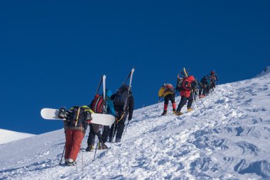 Group of climbers with skis and snowboards clipart