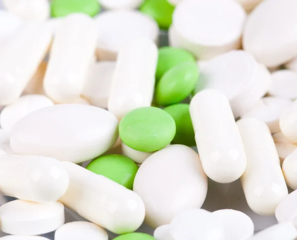 Heap de comprimidos brancos e verdes — Fotografia de Stock