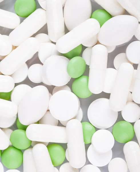 Haufen weißer und grüner Pillen — Stockfoto