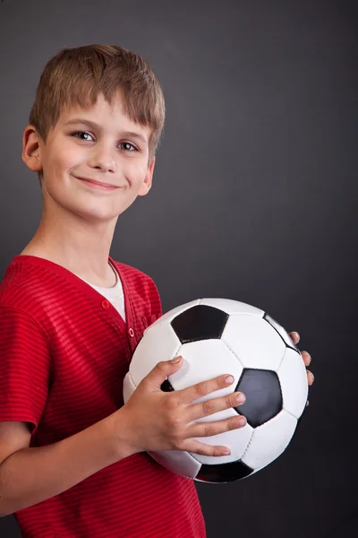 Cute boy is holding a football ball. Soccer ball — Stock Photo, Image