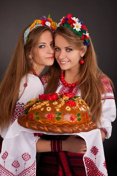 Mujeres jóvenes en ropa ucraniana, con guirnalda y pan redondo en — Foto de Stock