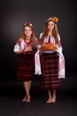 garland ve yuvarlak somun ile Ukrayna giysili genç kadınlar
