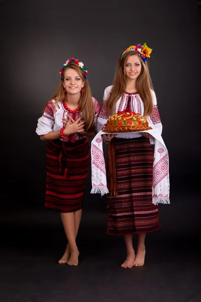 Jovens mulheres em roupas ucranianas, com guirlanda e pão redondo em — Fotografia de Stock