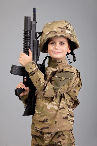 Young boy dressed like a soldier with rifle — Stock Photo, Image