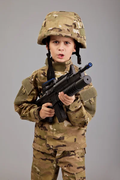 Мальчик, одетый как солдат с винтовкой — стоковое фото