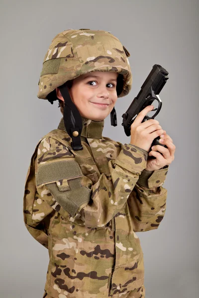 Νεαρό αγόρι ντυμένος σαν στρατιώτης με ένα πυροβόλο όπλο — Φωτογραφία Αρχείου