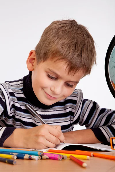 Cute schoolboy is writting — Stock Photo, Image