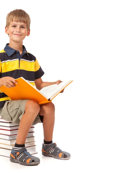 Schoolboy is sitting on books — Stock Photo, Image