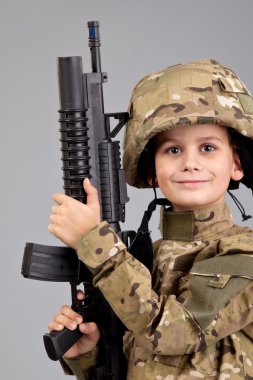 Young boy dressed like a soldier with rifle clipart