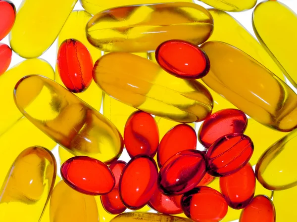 Doorzichtige gele en rode capsules. — Stockfoto
