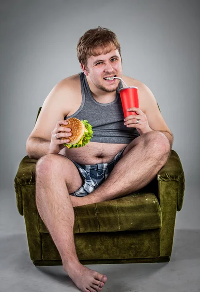 Fat man eating hamburger — Stock Photo, Image