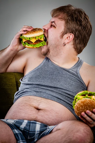 Dikke man eten hamburger — Stockfoto