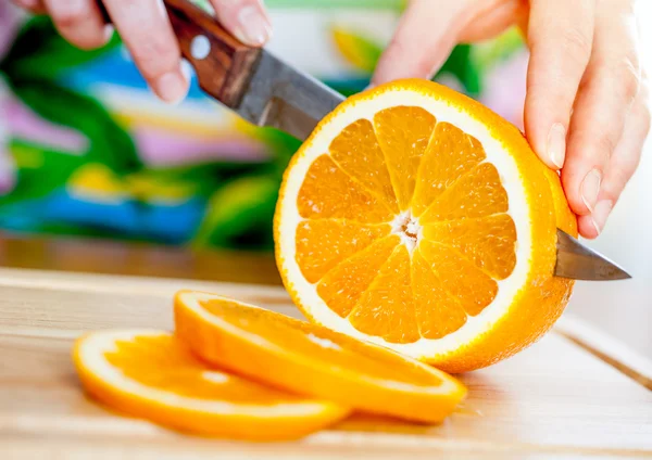 Las manos de la mujer corte naranja — Foto de Stock