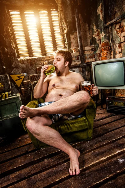 Товстий чоловік їсть гамбургер — стокове фото