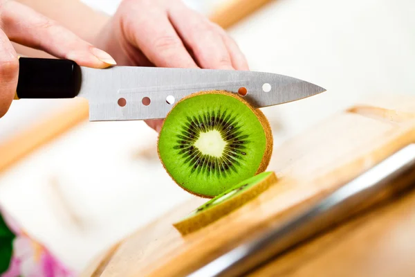Mani di donna taglio kiwi — Foto Stock