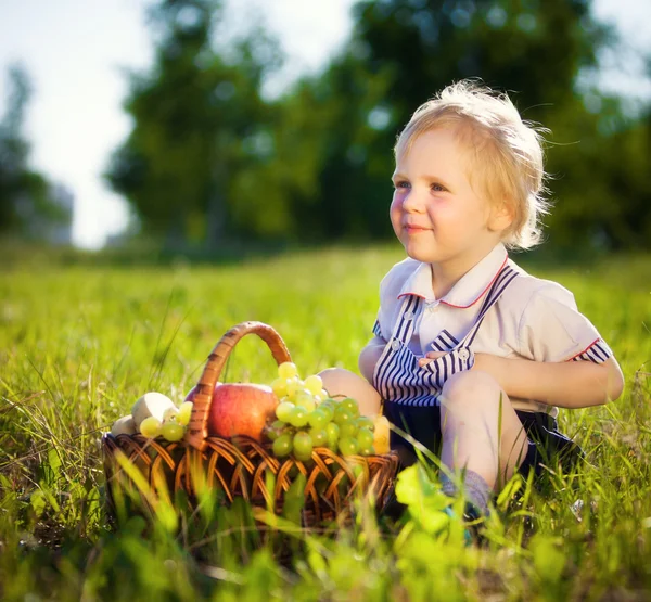 Little boy with a basket of fruit Stock Photo