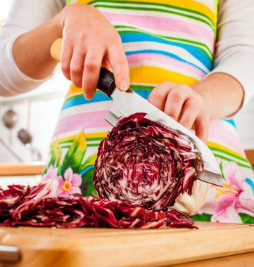 Woman's hands cutting red cabbage clipart