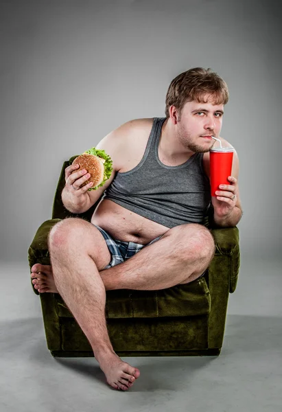 Tlustý muž jíst hamburger — Stock fotografie