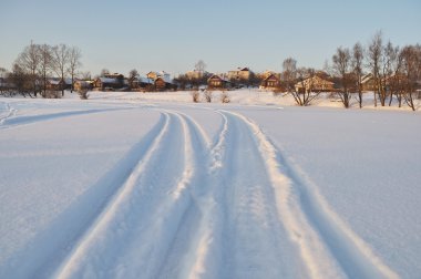 Houses next to icy lake, sunset clipart