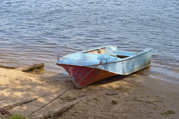 Металлическая лодка на берегу реки — стоковое фото