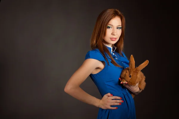 Retrato de una hermosa mujer con un conejo — Foto de Stock