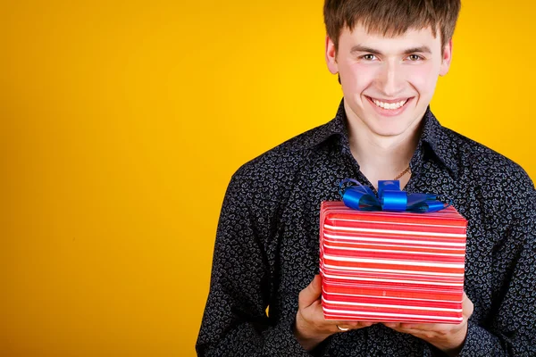 Mevcut hediye holding adam kamera bakan — Stok fotoğraf