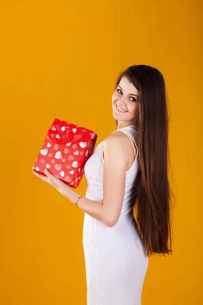 Vrouw in witte jurk met een cadeau — Stockfoto