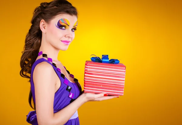 Красивая женщина с макияжем в платье с подарком — стоковое фото