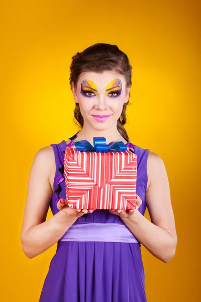 Krásná žena s make-upu v šatech s dárkem — Stock fotografie