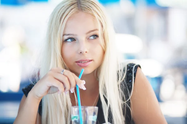 Portret van een blond mooie jonge vrouw in café — Stockfoto