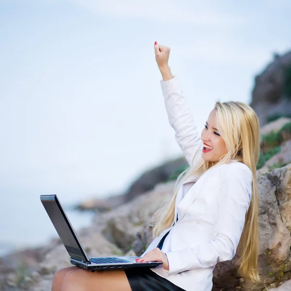 Красивая женщина на берегу моря с ноутбуком — стоковое фото