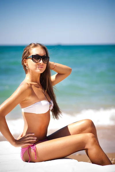 Vacker kvinna på en tropisk strand på en schäslong — Stockfoto